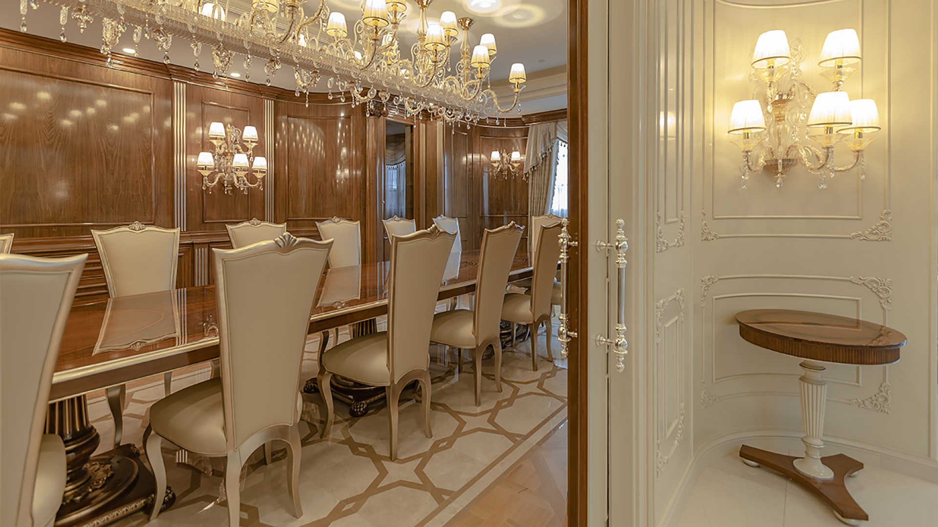 Ambleside Palace formal dining room entry with walnut paneling and crystal chandeliers in West Vancouver