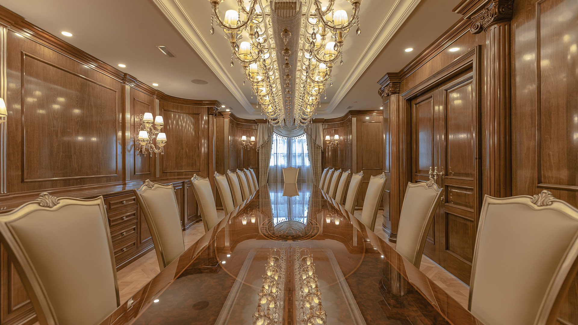 Ambleside Palace dining room symmetrical view with polished table reflecting crystal chandelier in West Vancouver