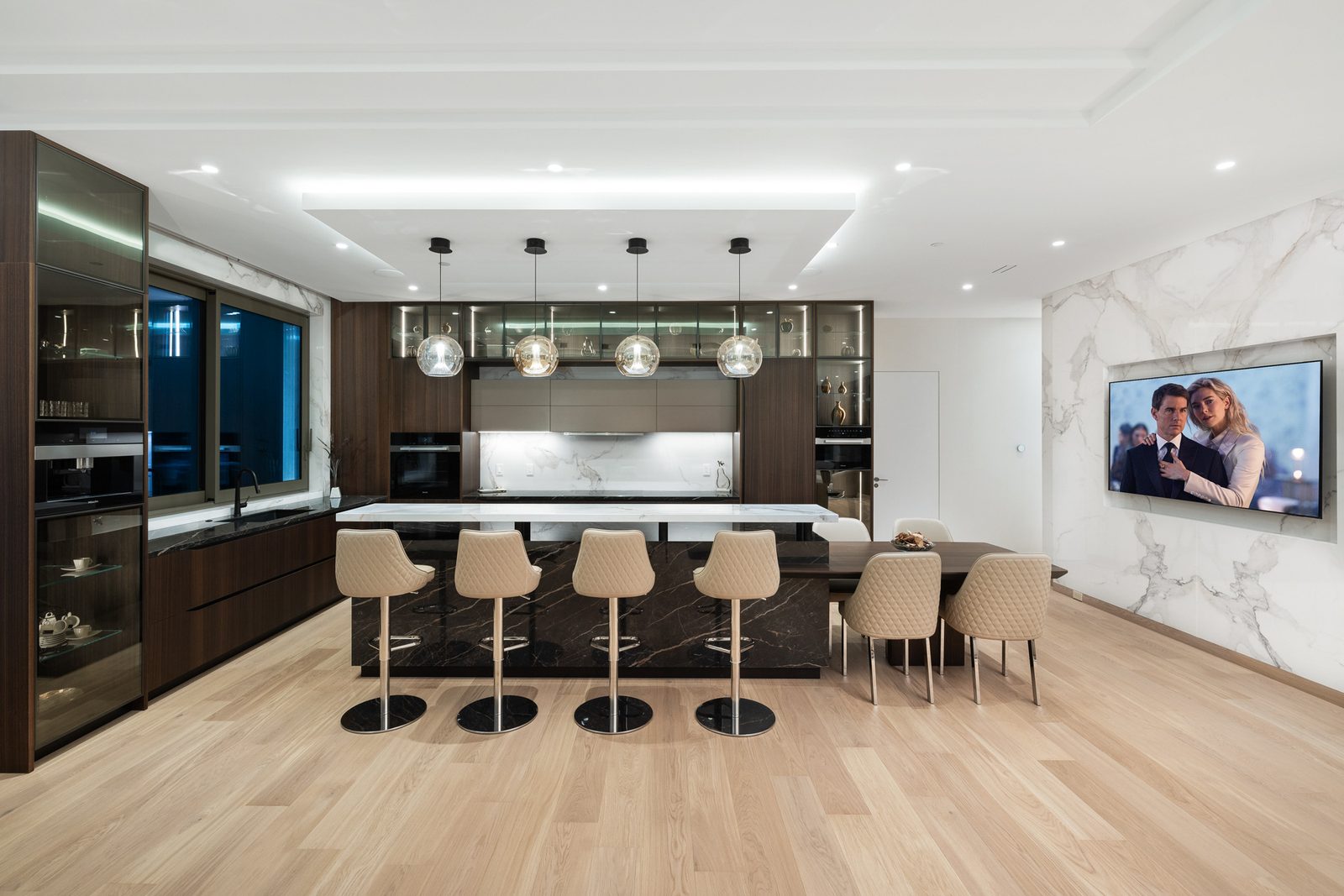 Designer kitchen with dark walnut cabinets calacatta marble backsplash and black stone waterfall island West Vancouver