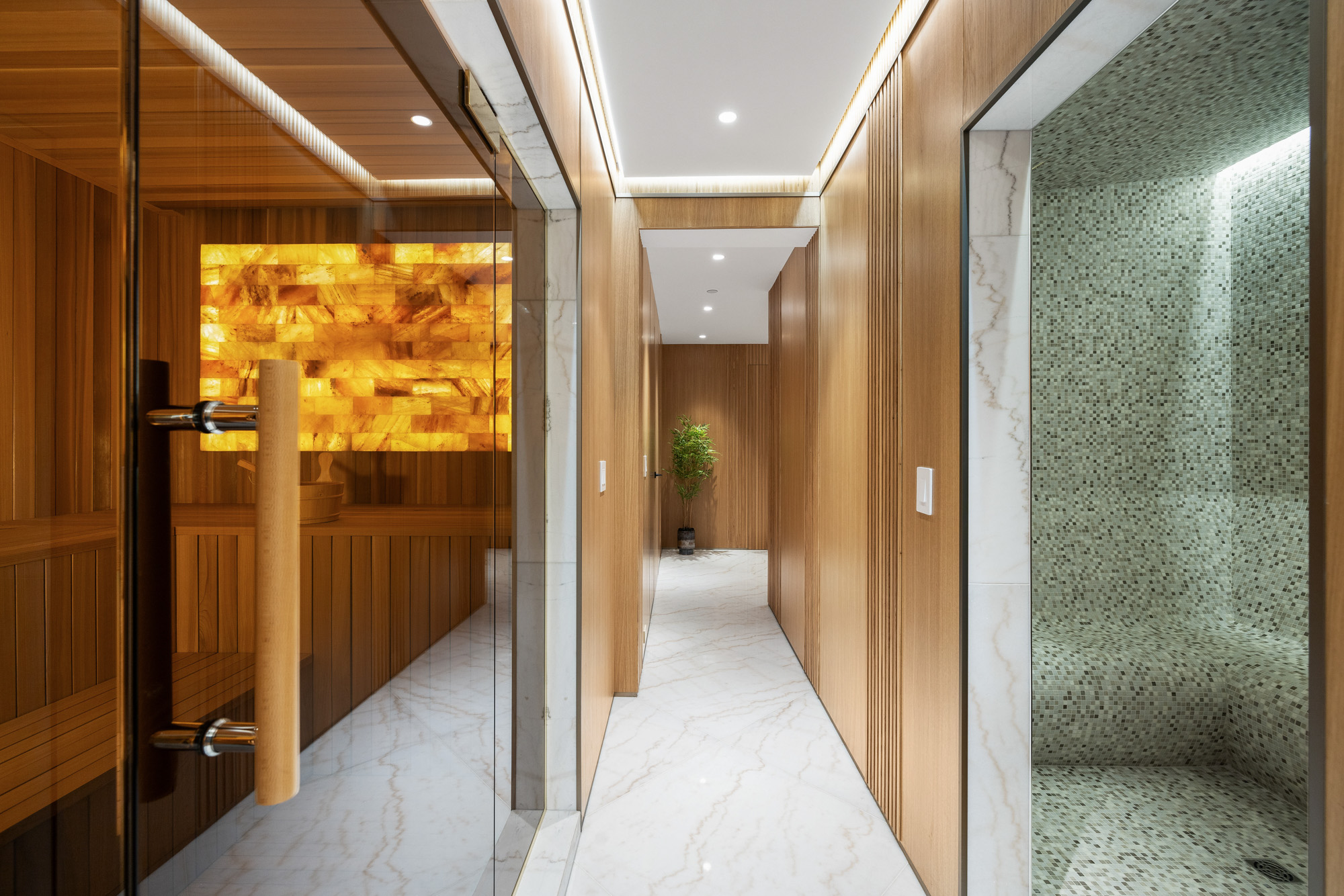 Spa corridor with cedar sauna glass door Himalayan salt wall and mosaic tiled steam room The Butterfly West Vancouver
