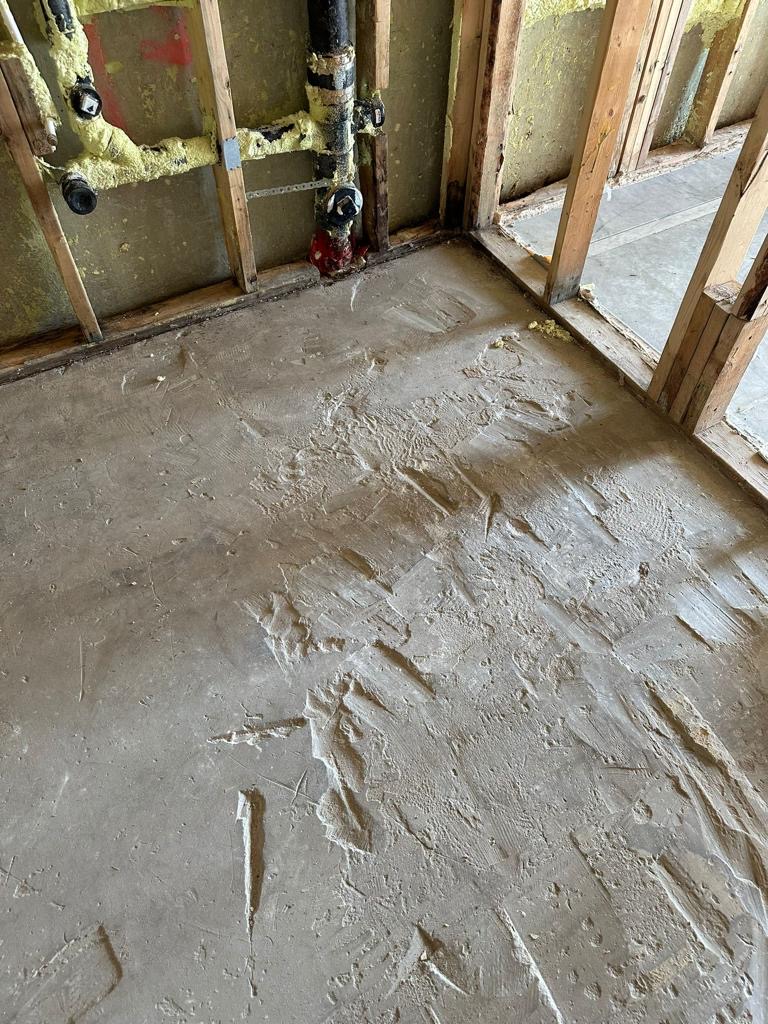 Subfloor damage after water intrusion — exposed framing and plumbing