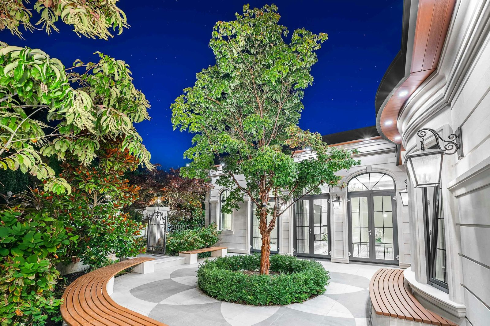 Interior courtyard atrium with mature trees and curved stone bench at Montbeau Eyremount