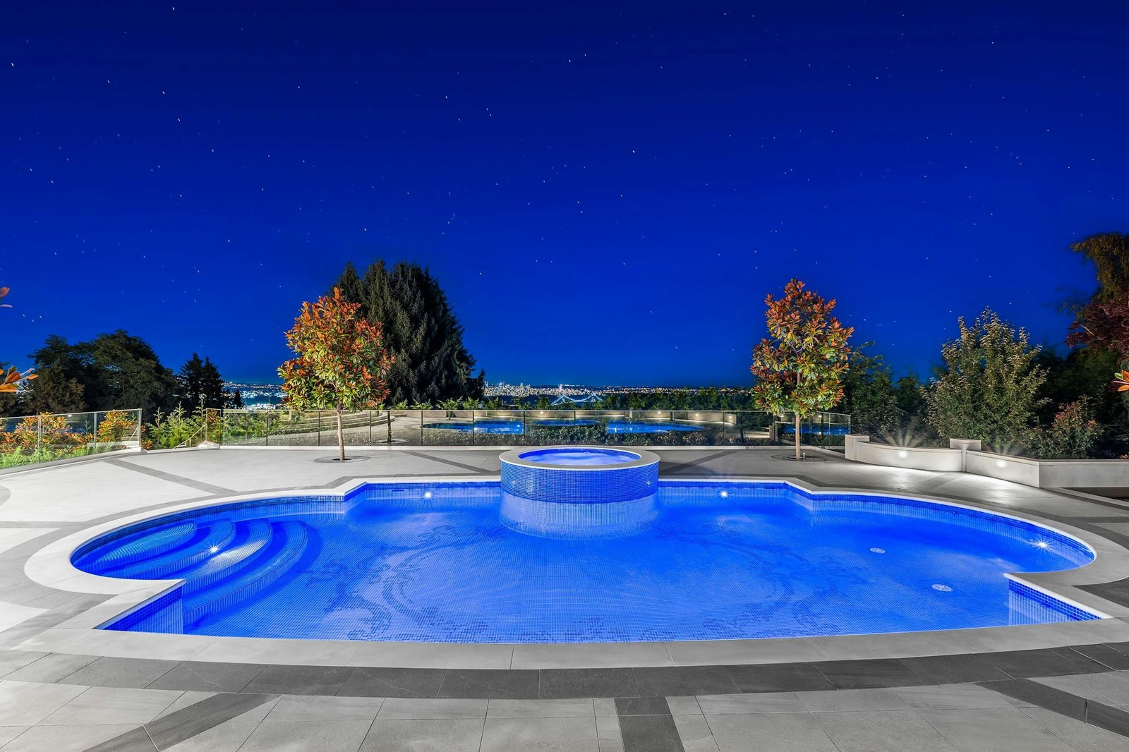 Outdoor swimming pool and hot tub with Vancouver city lights view at Montbeau Eyremount