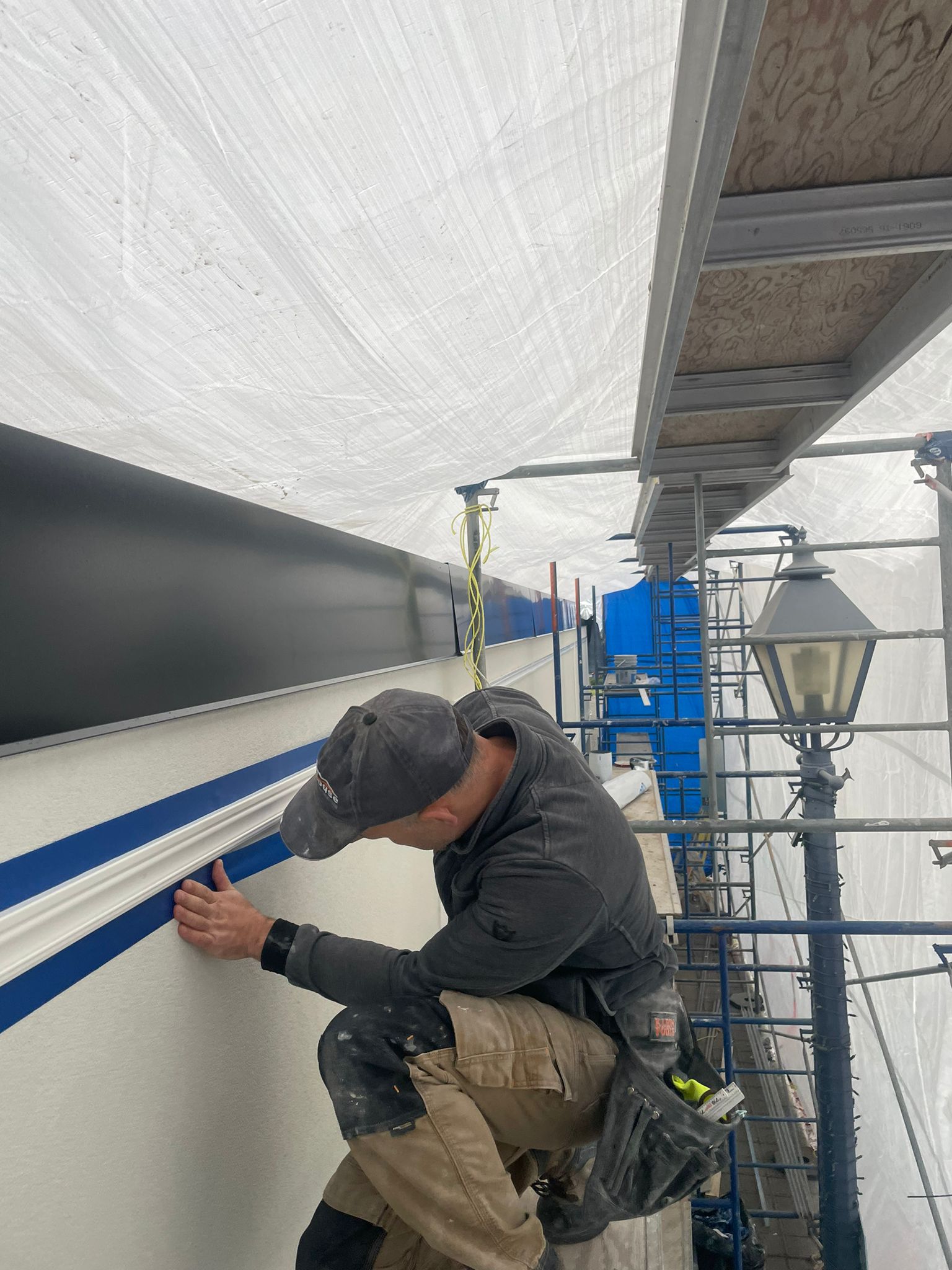 Eurohouse crew member on scaffolding performing detailed facade moulding work on the Pierwell presentation centre