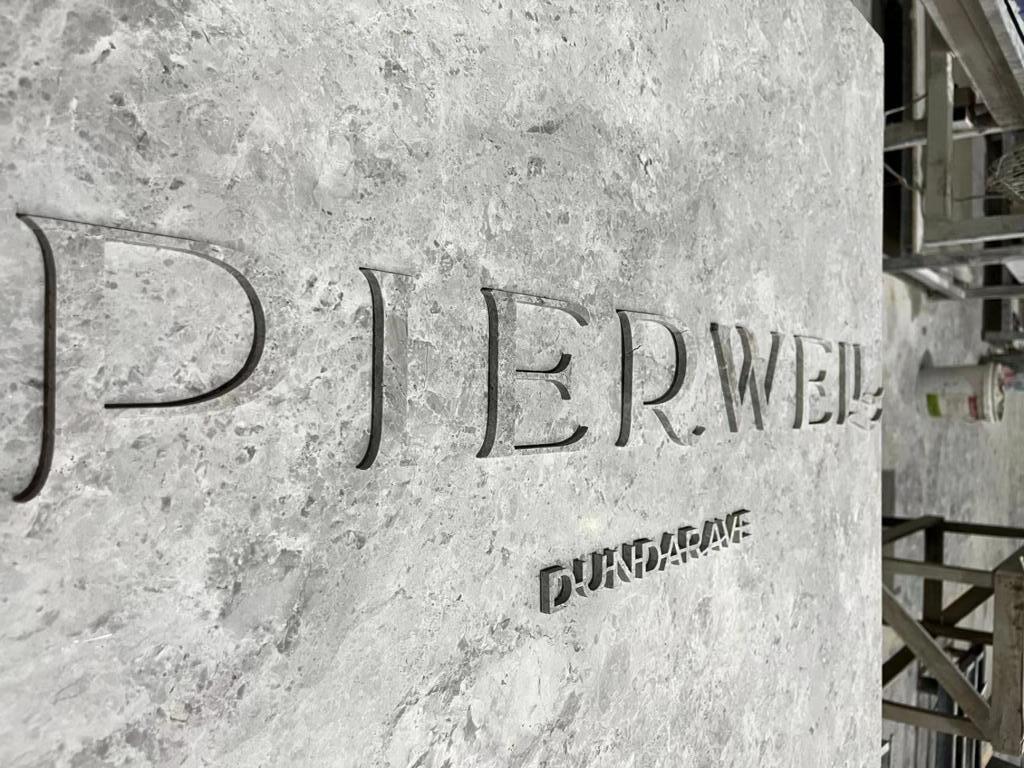 Pierwell Dundarave branded marble reception desk with cut metal lettering being fabricated in workshop