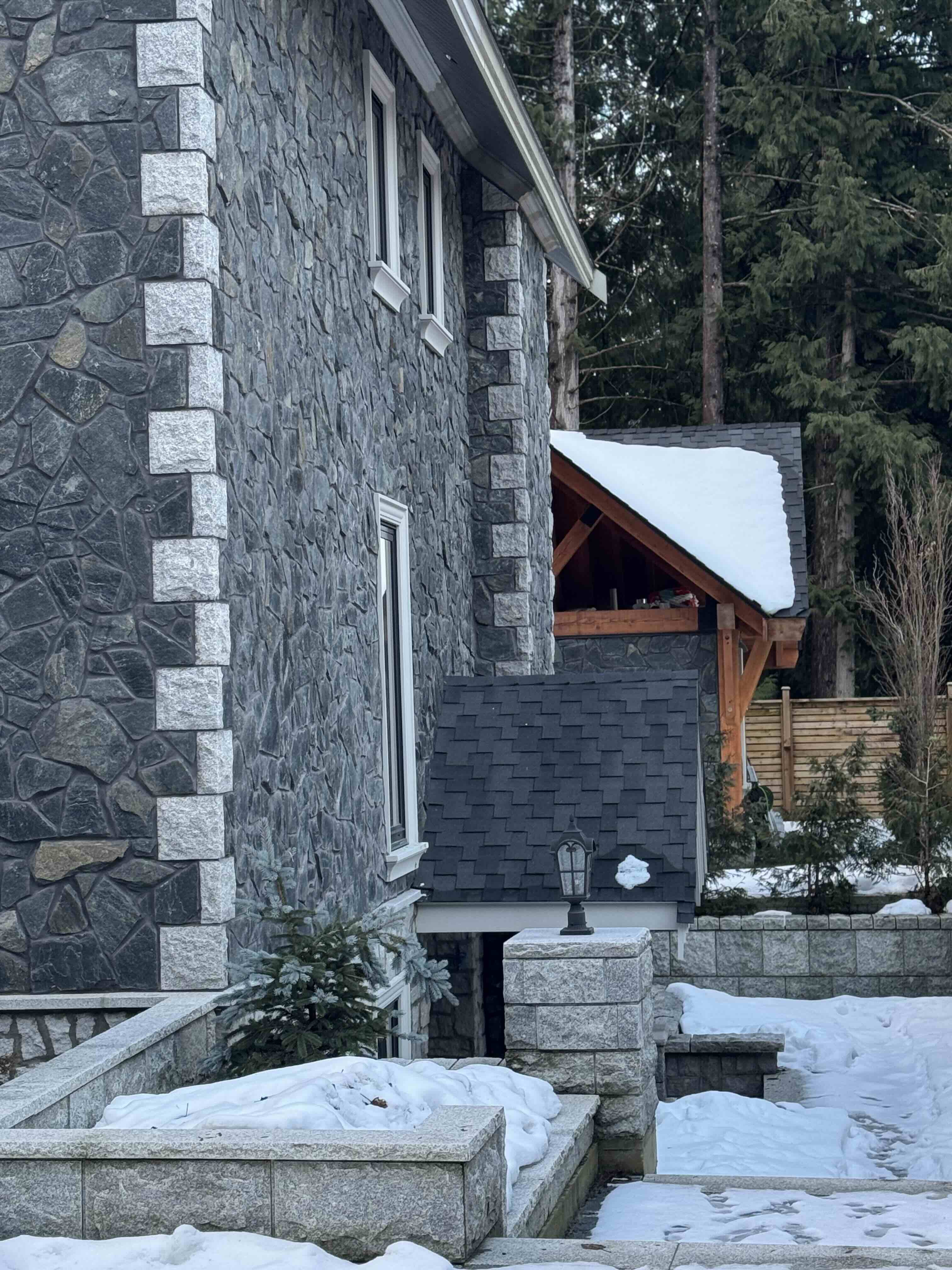 Stone facade detail showing natural stone cladding and timber gazebo at Rainbow in Whistler custom home by Eurohouse Construction