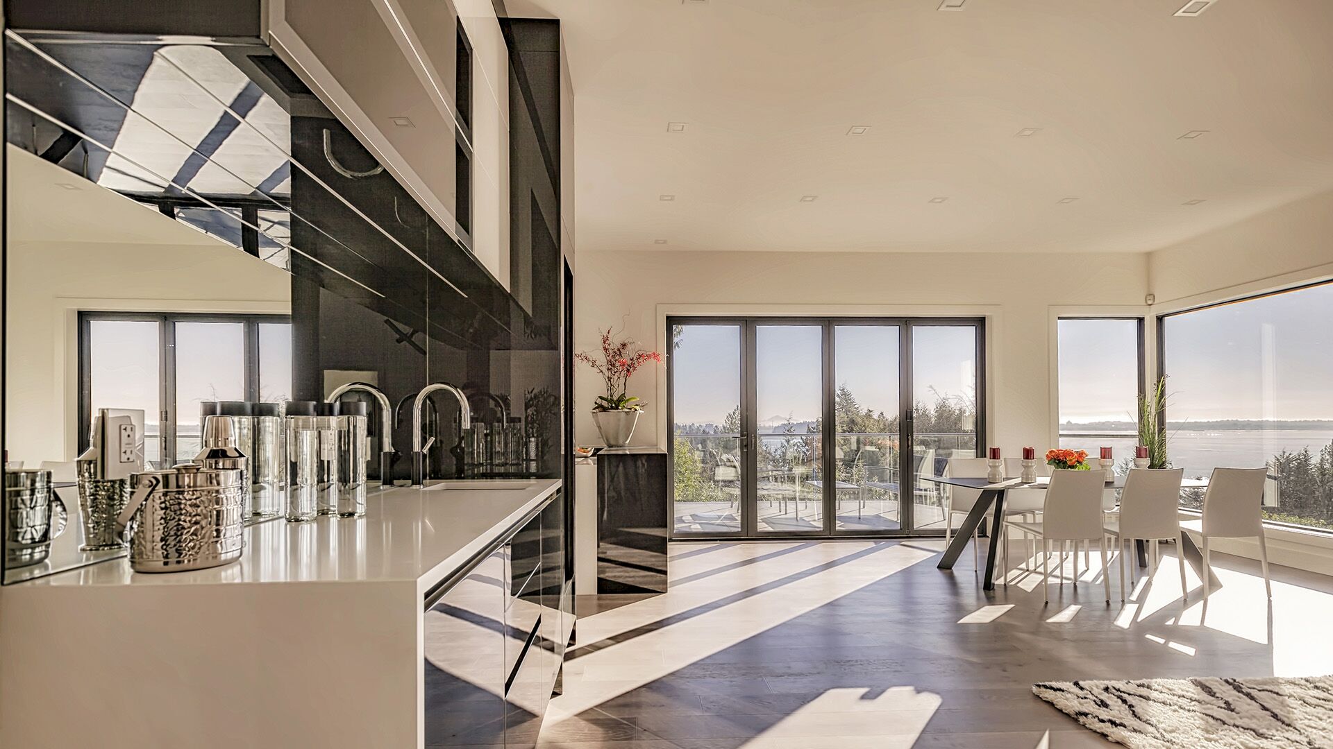 West Vancouver kitchen with ocean views through floor-to-ceiling windows, Italian lacquer cabinetry and dining area, designed by Eurohouse Construction