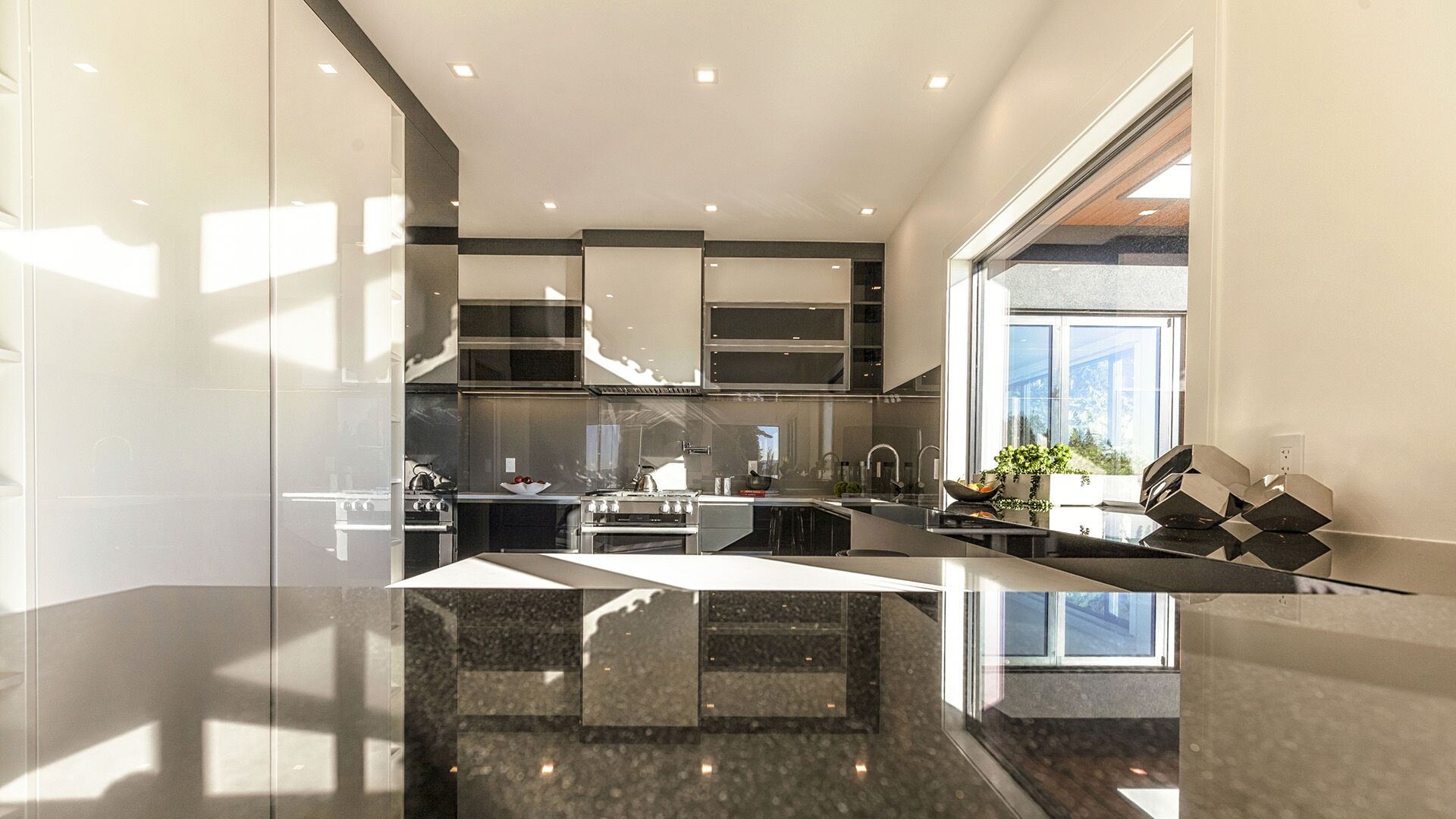 Italian lacquer kitchen countertop detail showing granite surface and professional-grade appliances with ocean views, installed by Eurohouse Construction