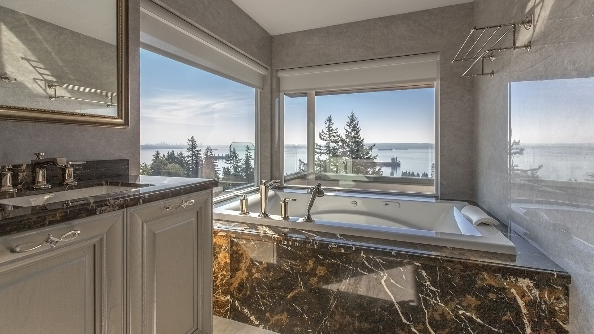 Marble soaking tub with corner window ocean views downtown Vancouver skyline and polished nickel fixtures at Rockridge Classic built by Eurohouse Construction