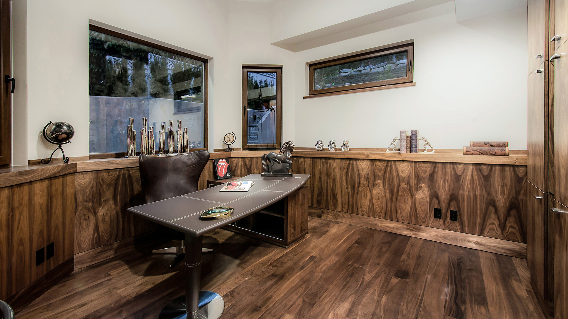 Walnut-panelled home office with custom millwork leather executive desk and garden views West Bay luxury West Vancouver home