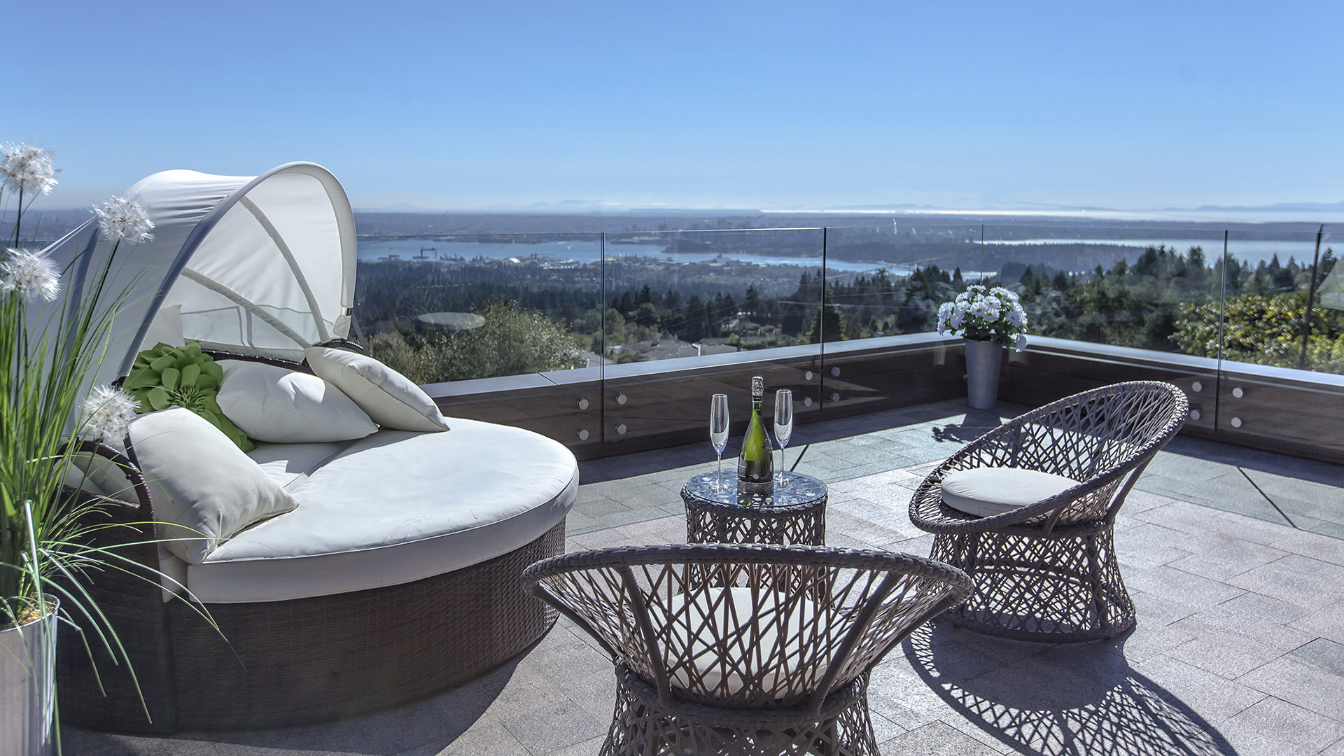 Rooftop deck with 270 degree panoramic views of Lions Gate Bridge Downtown Vancouver and Stanley Park featuring luxury outdoor furniture and glass railings West Coast Contemporary British Properties