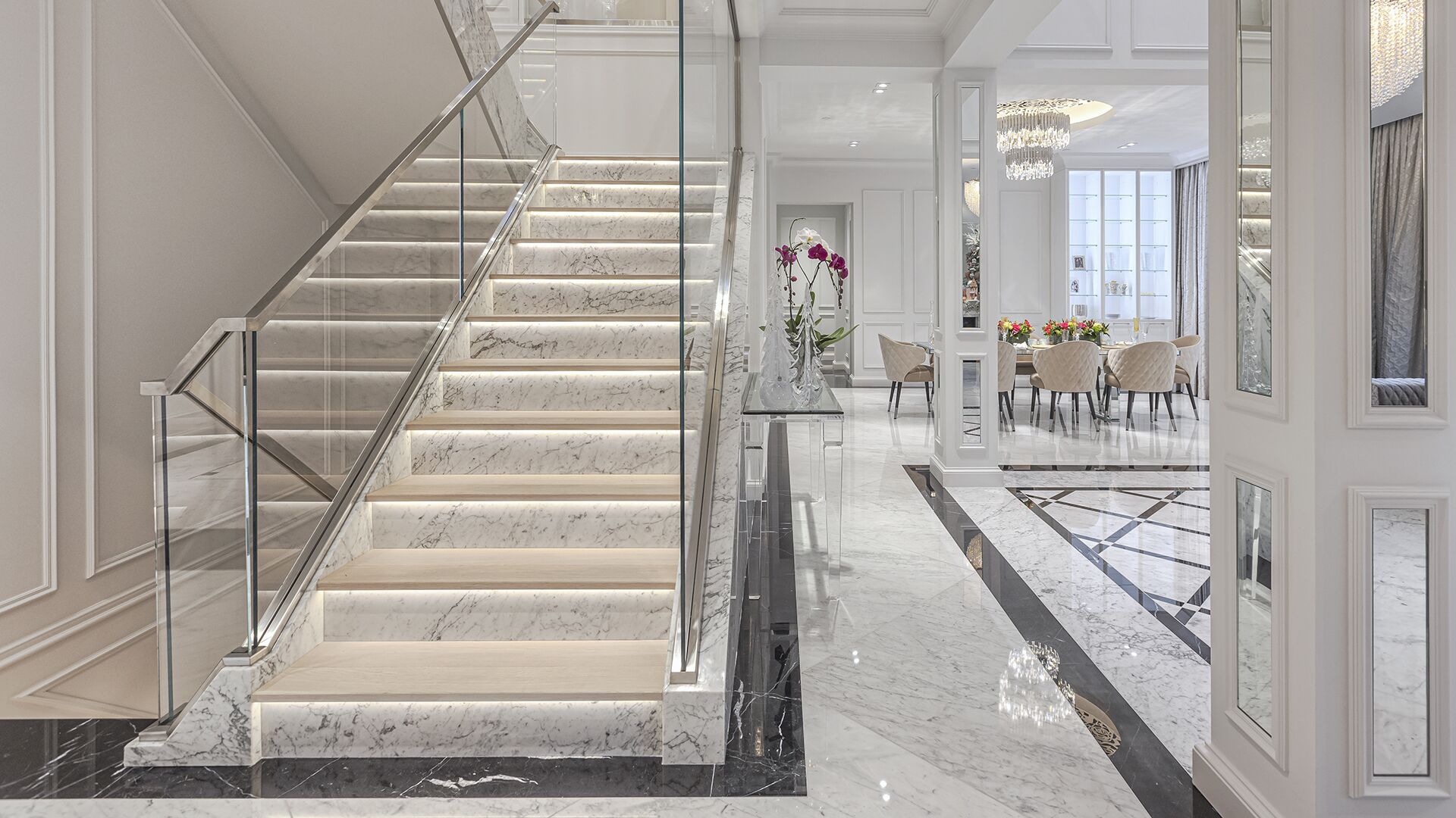 Illuminated marble staircase with glass chrome railing and LED lighting in luxury West Vancouver home built by Eurohouse Construction